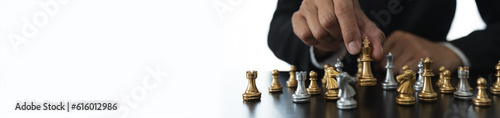 businessman concept, investor holding chess pieces playing chess board game in business competition and risk management plan business strategy leadership concept, copy space, panorama, banner
