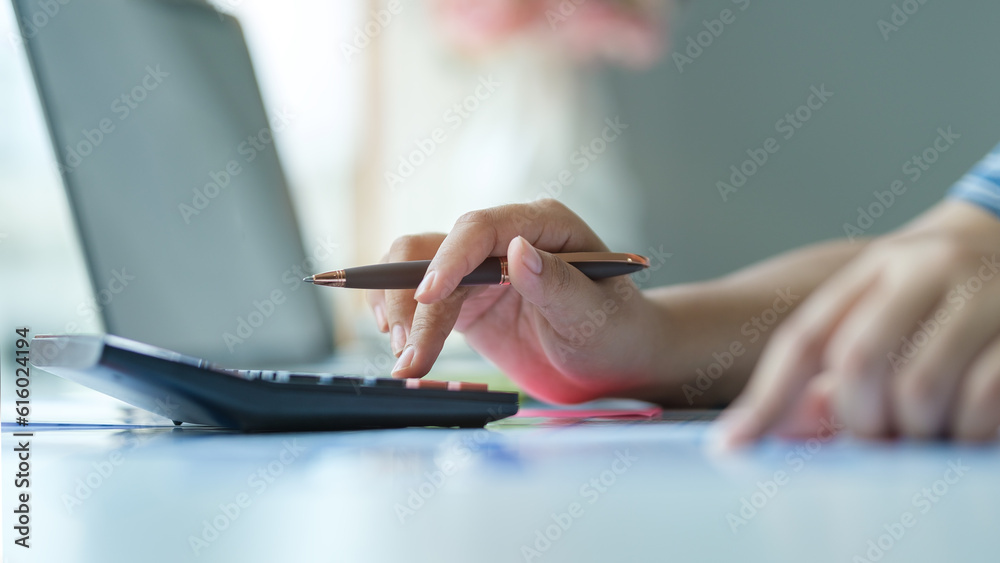 Closeup view of woman using calculator, counting money, expenses, analyzing bills, managing household finances. Closeup view of woman using calculator, counting money, expenses, analyzing bills, managing household finances.