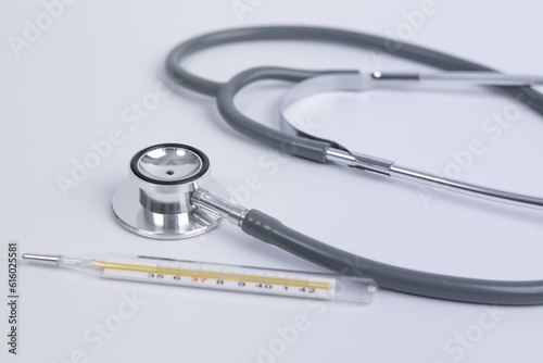 Close up Gray stethoscope beside thermometer on white background for doctor and medical nursing people check up healing of patients in hospital. healthcare concept. medical Insurance concept.