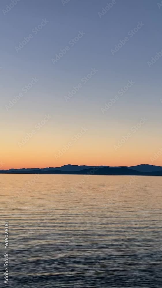sunset on Pacific Ocean calm silhouette of man floating on the board Surfing in evening in hands of a man a paddle sunset on Pacific Ocean calm silhouette of man floating on the board Surfing in evening in hands of a man a paddle