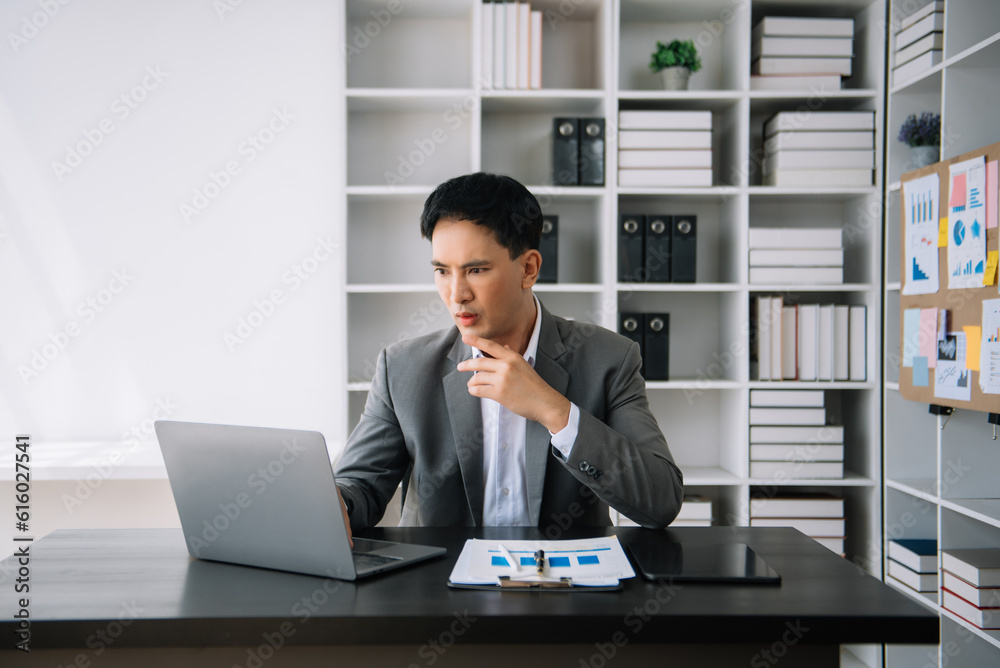 Asian business man is stressed, bored, and overthinking from working on a tablet at the modern office. Asian business man is stressed, bored, and overthinking from working on a tablet at the modern office.