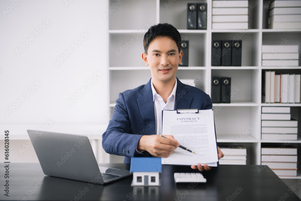 Asian man working with House model real estate agent and customer discussing for contract to buy house, insurance or loan real estate consult concerning mortgage loan offer Asian man working with House model real estate agent and customer discussing for contract to buy house, insurance or loan real estate consult concerning mortgage loan offer