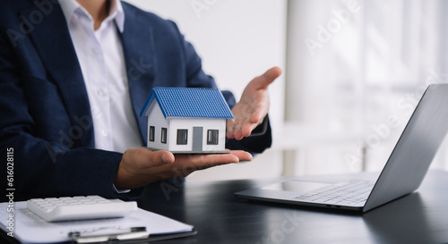 Real estate broker agent presenting to customer to decision making sign insurance form agreement, buy and sell home model, concerning mortgage loan offer