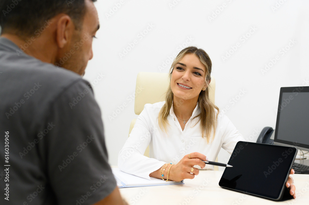 Happy woman doctor showing tablet screen to patient Happy woman doctor showing tablet screen to patient