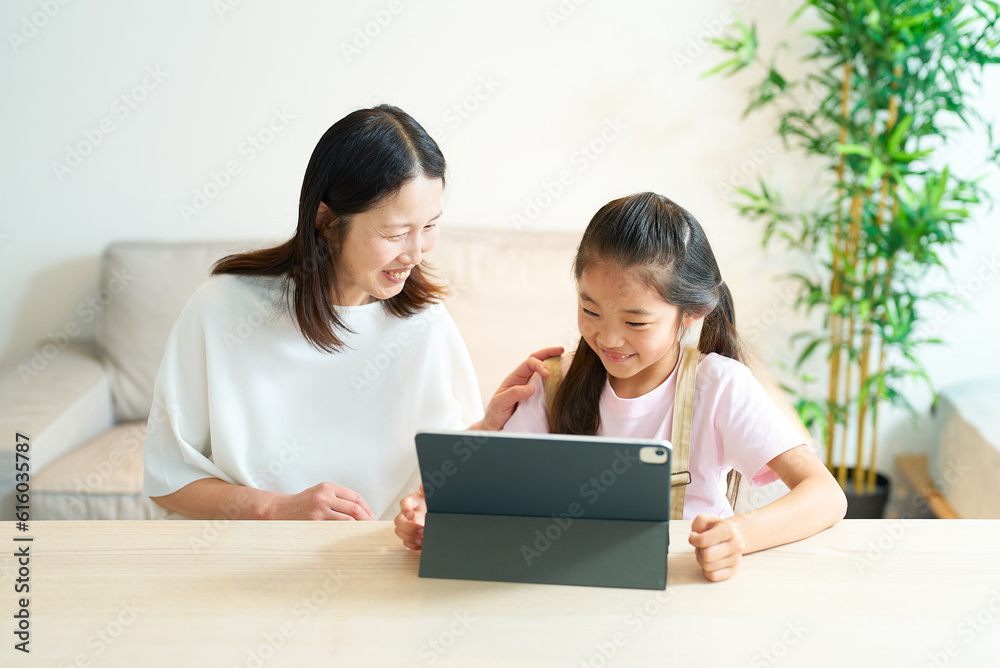タブレットPCの画面を見る笑顔の親子 タブレットPCの画面を見る笑顔の親子