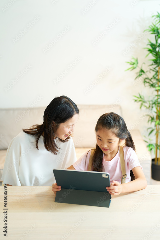 タブレットPCの画面を見る笑顔の親子 タブレットPCの画面を見る笑顔の親子