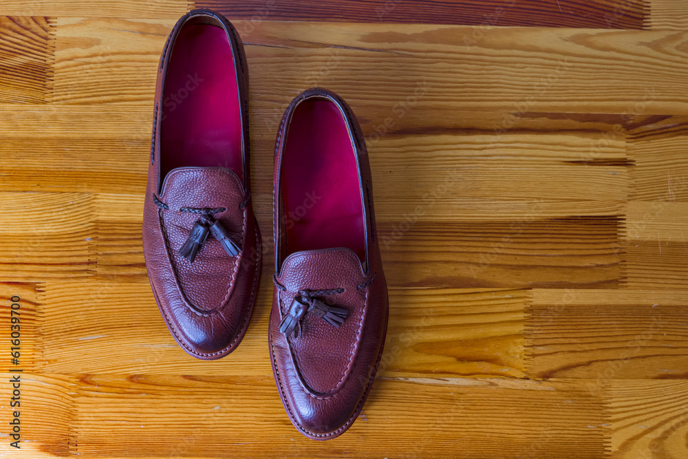 Pair of Wonderful Traditional Formal Stylish Brown Pebble Grain Tassel Loafer Shoes Inline Placed On Wooden Surface Pair of Wonderful Traditional Formal Stylish Brown Pebble Grain Tassel Loafer Shoes Inline Placed On Wooden Surface