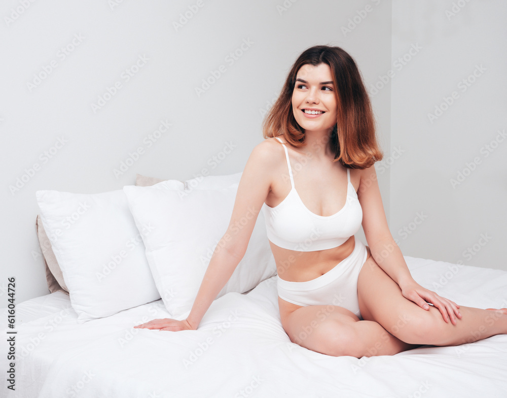 Attractive and relaxed seductive young woman with slim body wearing white underwear. Sexy smiling model lying on sheets in the bedroom at home in the early morning in lingerie. Happy female in bed Attractive and relaxed seductive young woman with slim body wearing white underwear. Sexy smiling model lying on sheets in the bedroom at home in the early morning in lingerie. Happy female in bed