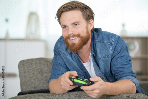 happy young addicted man playing video games in living room