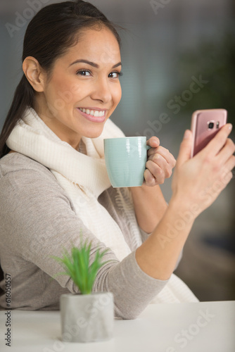 happy woman holding coffee and phone