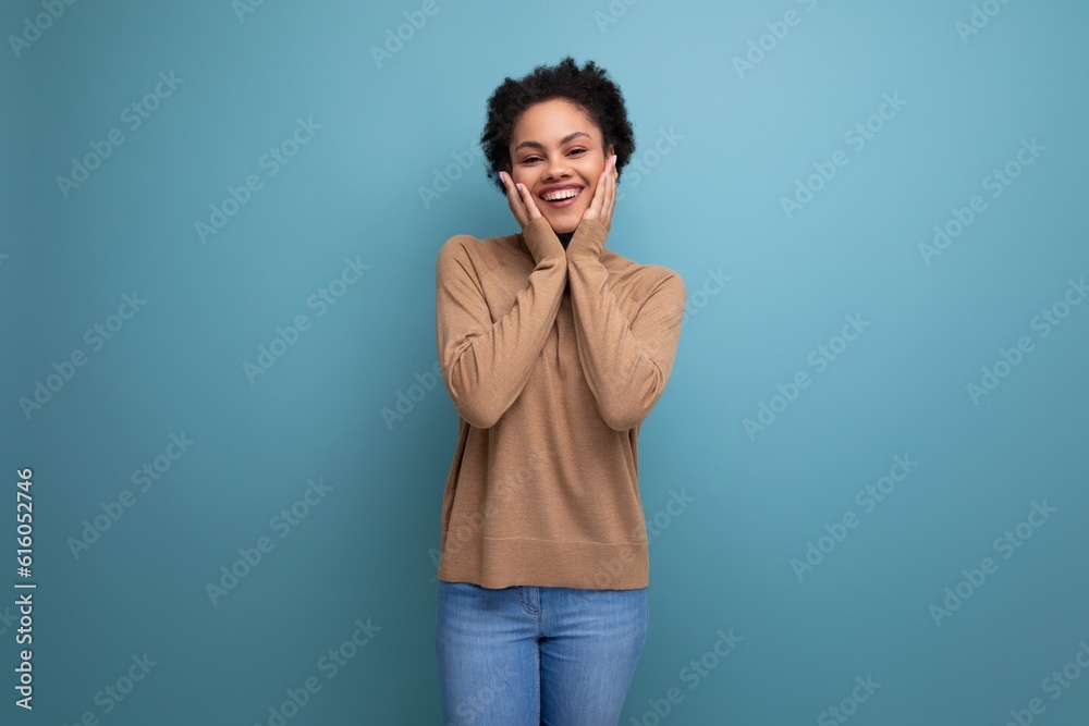 young enthusiastic bright latin woman with curly hair smiling on background with copy space