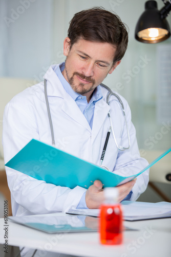 medical doctor reading a report document at his office