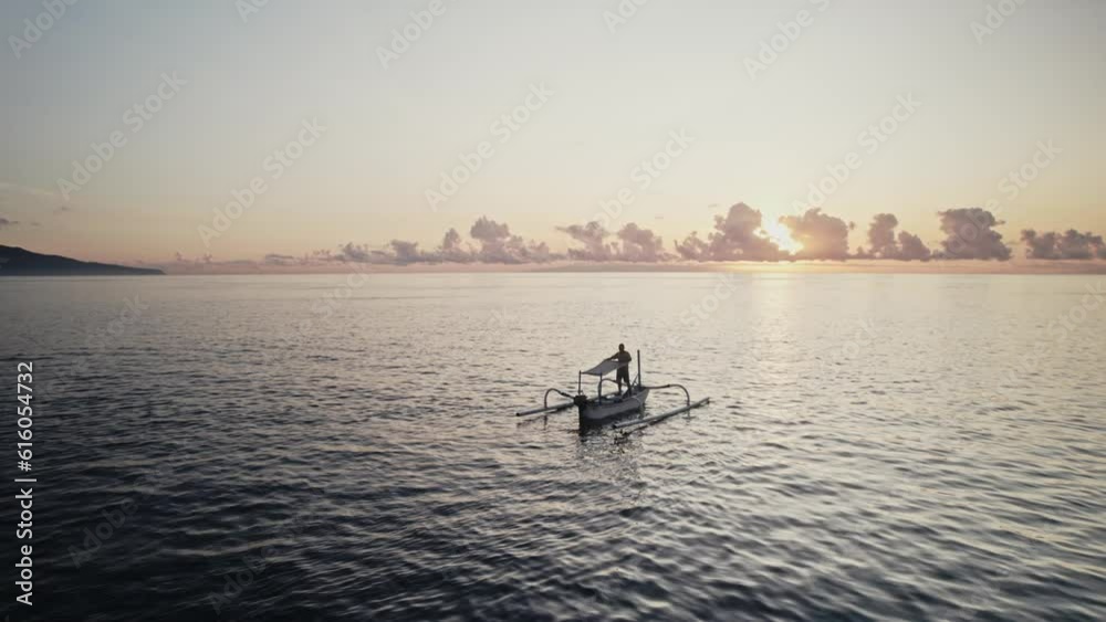 lonely fisherman in to the ocean with traditional wooden boat at sunset aerial footage lonely fisherman in to the ocean with traditional wooden boat at sunset aerial footage