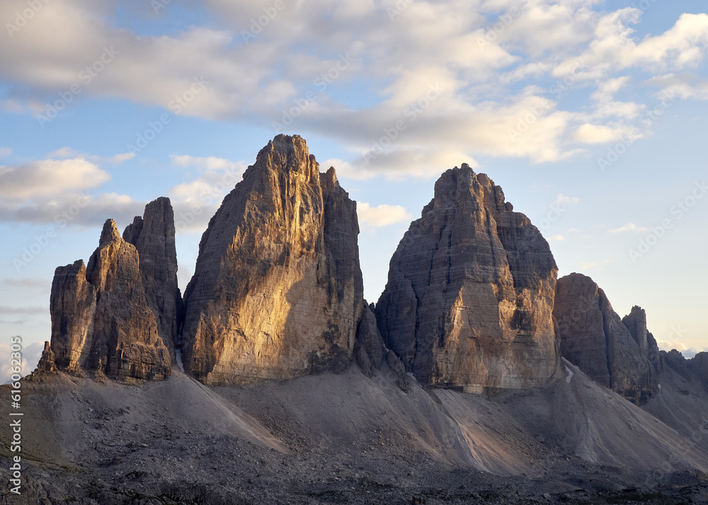 The imposing dolomite peaks of Tre Cime di Lavaredo illuminated by the sunset light in autumn