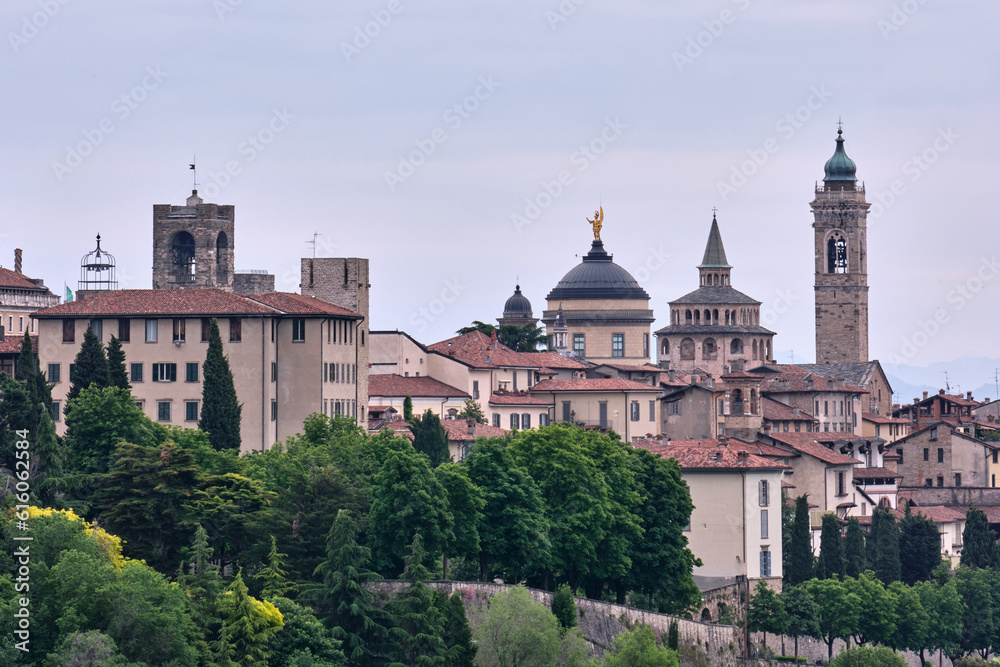 The profile view of the beautiful medieval upper city of Bergamo with the Po Valley in the background at sunrise