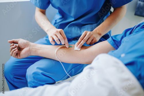  Friendly Female Head Nurse Making Rounds does Checkup on Patient Resting in Bed. She Checks tablet while Man Fully Recovering after Successful Surgery in hospital.