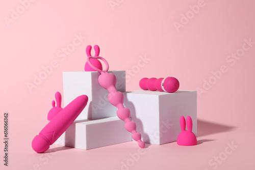 Composition of pink sex toys with cubes on a pink background photo