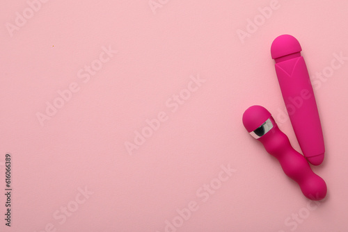 Two pink vibrators on a pink background, place for text