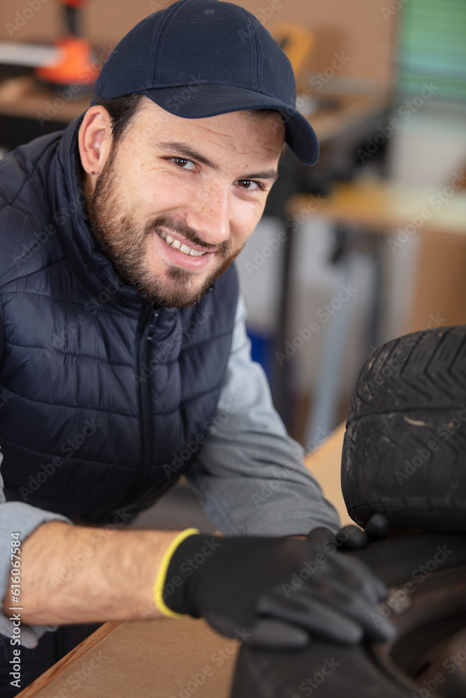 mechanic holding a tire tire at the repair garage