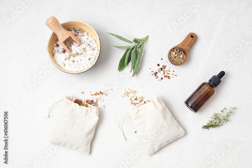 Botanical blends in cotton bags, salt, herbs, essencial oils for naturopathy. Natural remedy, herbal medicine, blends for bath and tea on wooden table background