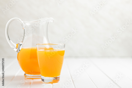 A glass of fruit juice. Orange  juice on white table.