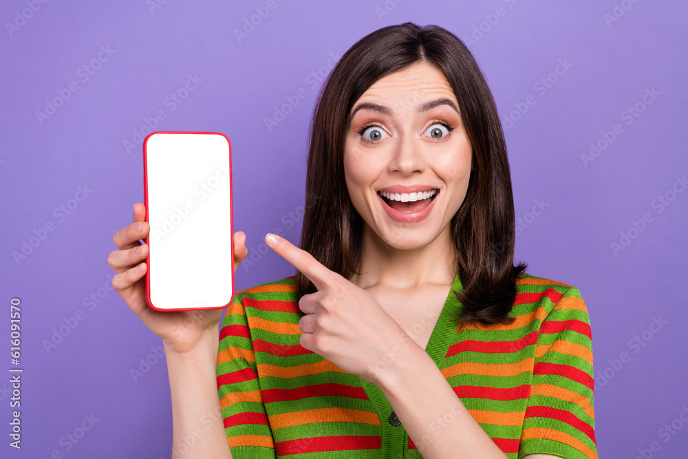 Portrait of overjoyed astonished lady wear trendy clothes demonstrate electronic device empty space isolated on purple color background Portrait of overjoyed astonished lady wear trendy clothes demonstrate electronic device empty space isolated on purple color background