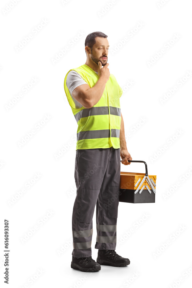 Road assistance mechanic holding a tool box and thinking Road assistance mechanic holding a tool box and thinking