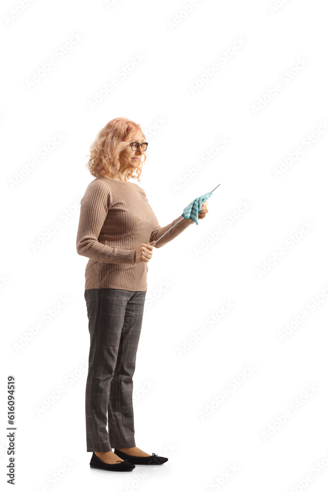 Full length profile shot of a woman cleaning a dipstick for car engine oil check Full length profile shot of a woman cleaning a dipstick for car engine oil check