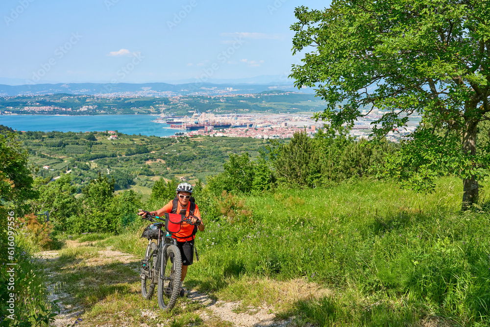 nice active senior woman on a mountain bike tour at the Slovenian Mediterranen cost above Koper at Capodistria