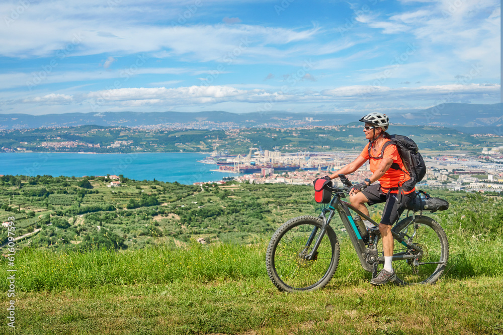 Obraz premium nice active senior woman on a mountain bike tour at the Slovenian Mediterranen cost above Koper at Capodistria