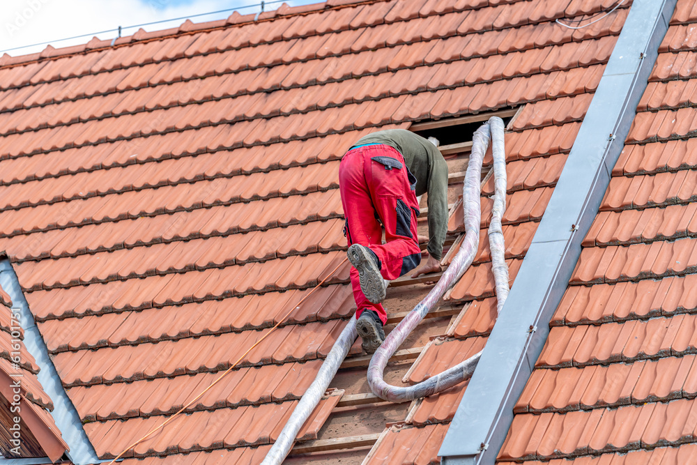 craftsman on the stairs, blowing foam roof insulation, application with the help of a pressure hose craftsman on the stairs, blowing foam roof insulation, application with the help of a pressure hose