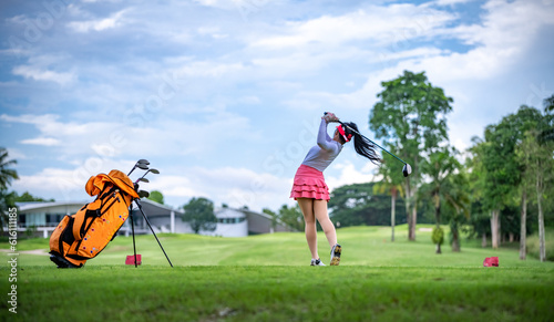 Professional woman golfer teeing to hole in player tournament competition at golf course for winner with green golf background. 