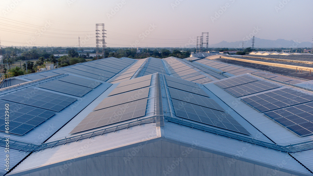 Future green energy and sustainable electricity resource concept. Outdoor focus on solar panels on rooftops or photovoltaics of factories by drone. Industrial roof with solar cell grid with blue tone.