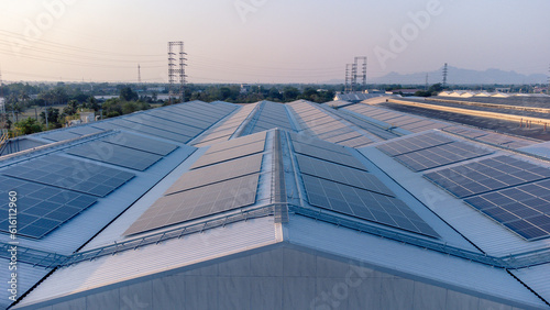 Future green energy and sustainable electricity resource concept. Outdoor focus on solar panels on rooftops or photovoltaics of factories by drone. Industrial roof with solar cell grid with blue tone.