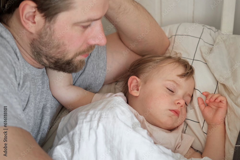 Father and his little daughter toddler girl sleeping together. Healthy sleep. Happy Loving family parent and child sleeping white bed at home. Authentic lifestyle fatherhood moments. Single dad life Father and his little daughter toddler girl sleeping together. Healthy sleep. Happy Loving family parent and child sleeping white bed at home. Authentic lifestyle fatherhood moments. Single dad life