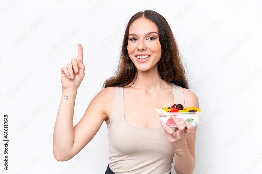 Young caucasian woman holding a bowl of fruit isolated on white background pointing up a great idea Young caucasian woman holding a bowl of fruit isolated on white background pointing up a great idea
