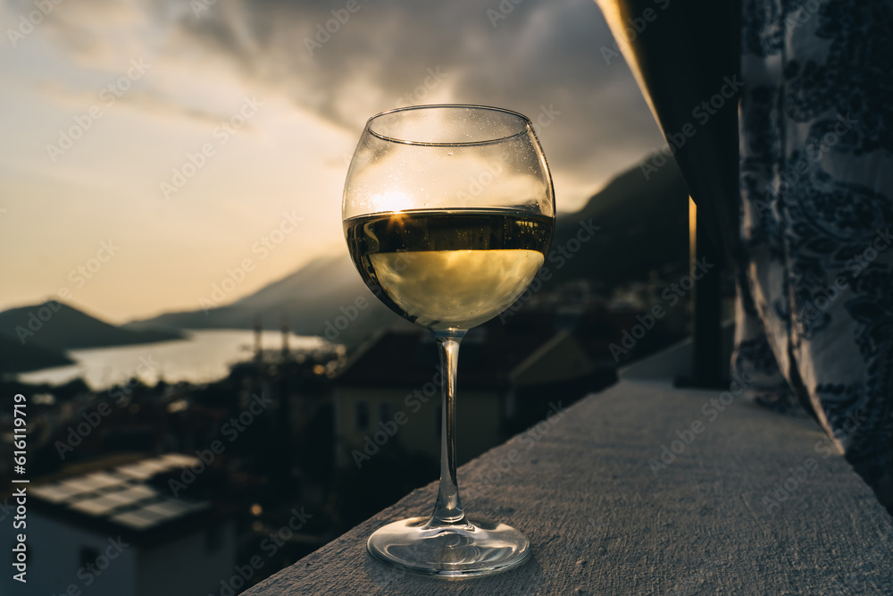 White wine in glass, view of sunset town. White wine in glass, view of sunset town.