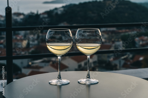 White wine in glass, view of sunset town.