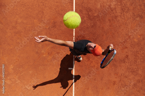Top view of a professional tennis player serves the tennis ball on the court with precision and power © .shock