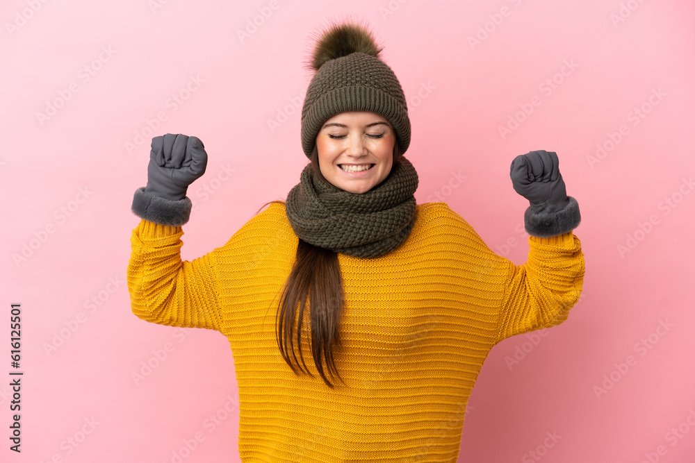 Young caucasian girl with winter hat isolated on pink background doing strong gesture Young caucasian girl with winter hat isolated on pink background doing strong gesture