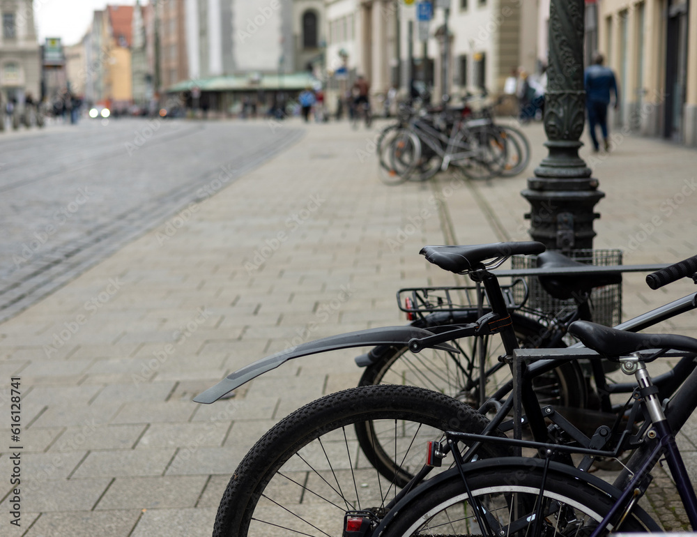 many bicycle on parking lot next to building urban city style street photo.close up wheel tires bike parts,basket,handlebars.bicycle in a row