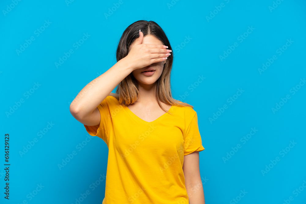 Young Russian girl isolated on blue background covering eyes by hands. Do not want to see something Young Russian girl isolated on blue background covering eyes by hands. Do not want to see something
