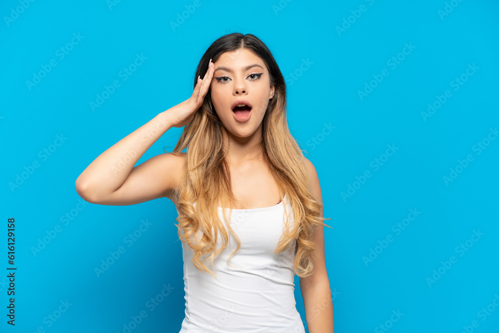 Young Russian girl isolated on blue background has realized something and intending the solution