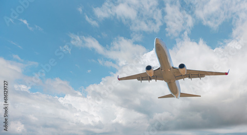 White passenger airplane flying in the sky amazing clouds in the background - Travel by air transport