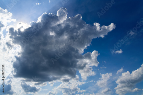 Cloudy sky with upcoming rain showers above Sauerland, Germany. Panoramic view with dramatic sunlight, contrasting dark and white clouds and blue to bright background with summer weather conditions. © ON-Photography
