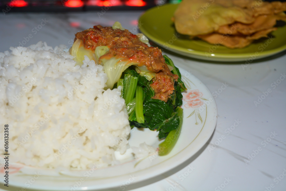 A plate of pecel rice, on a white background. A plate of pecel rice, on a white background.