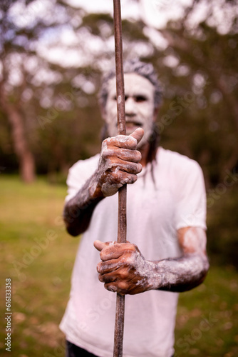 Dharawal man with a painted face holding a spear photo