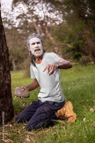 Aboriginal man in green bush surrounds telling stories photo