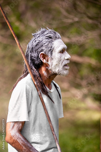 Aboriginal man in green bush surrounds telling stories photo