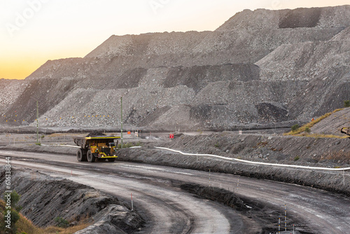 Trucks working late in the day on open cut coal mining extraction site photo